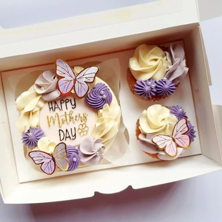 Pastel del Día de la Madre y cupcakes con mariposas y crema en tonos morados.