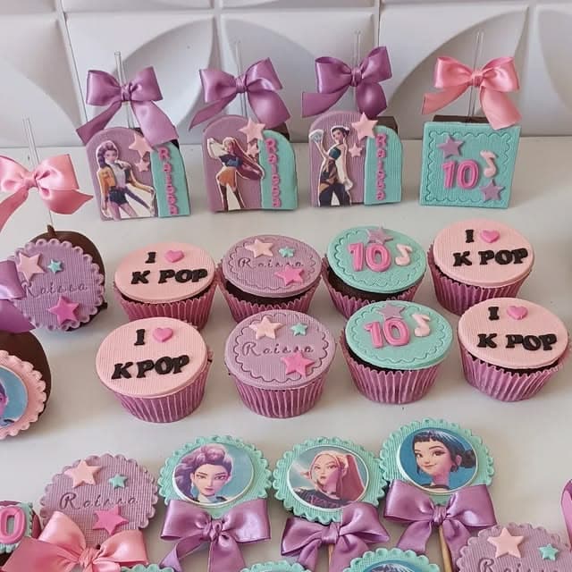Dulces y cupcakes temáticos de K-pop en colores pastel con lazos y personajes animados.
